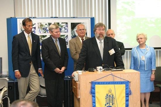 Thomas Loveland, chief scientist at EROS and co-director of the SDSU GIS Center of Excellence, speaks at the center’s Sept. 1, 2005, dedication. Behind him, from left, are Senator John Thune, Senator Tim Johnson, EROS Director R.J. Thompson, South Dakota Board of Regents Executive Director Robert (Tad) Perry and SDSU President Peggy Gordon-Miller. 