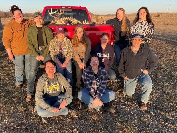 Wildlife and Fisheries conservation club went deer shed hunting during the spring semester.  The group stands around a red pickup bed where various deer bones are displayed, including a buck skull and spine bones.