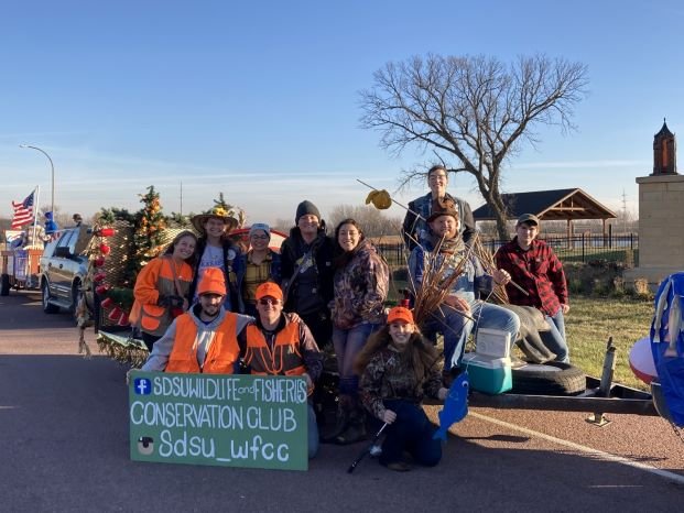  The Wildlife and Fisheries Conservation Club pose for a picture while on their 2022 Hobo Day parade float. Multiple students are dressed like hobos themselves the others are in hunter orange.