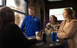 SDSU students visit with a Sioux Falls businesswoman about a social media campaign the students created for the business.