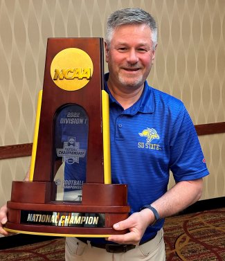 Todd Foster holds the 2022 Division I FCS Football Championship trophy.