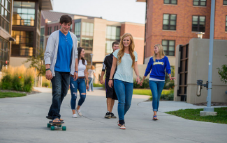 Students walking and skateboarding on campus