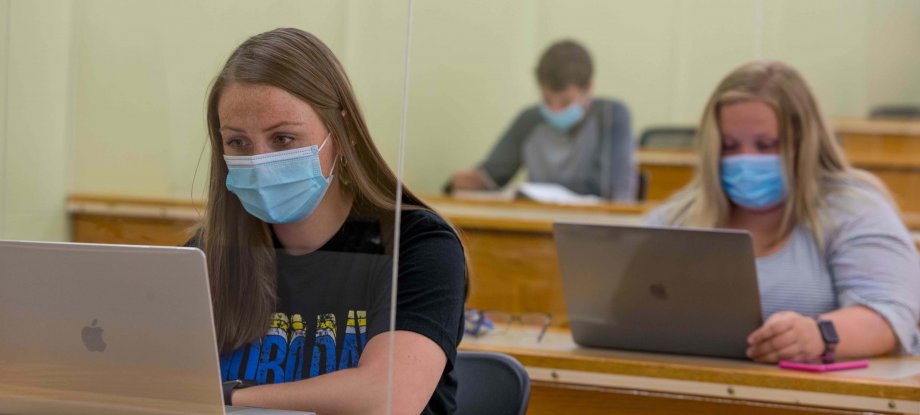 Students wearing masks while on their laptops