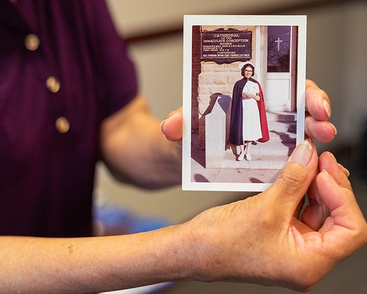Bev Warne holds a picture of herself when she attended St. John's McNamara School of Nursing