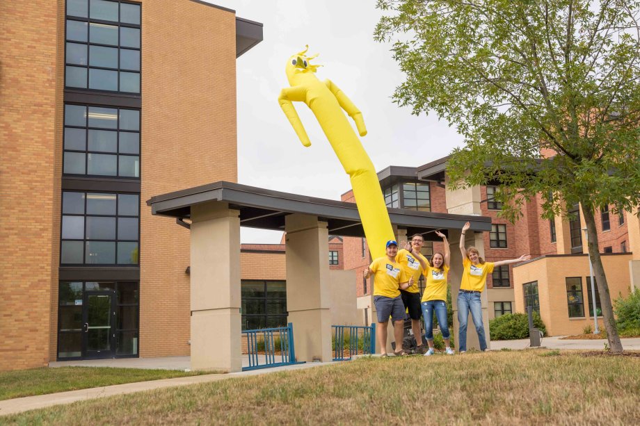Students wearing yellow shirts waving arms with air crazy hands figure to excite students for move in.