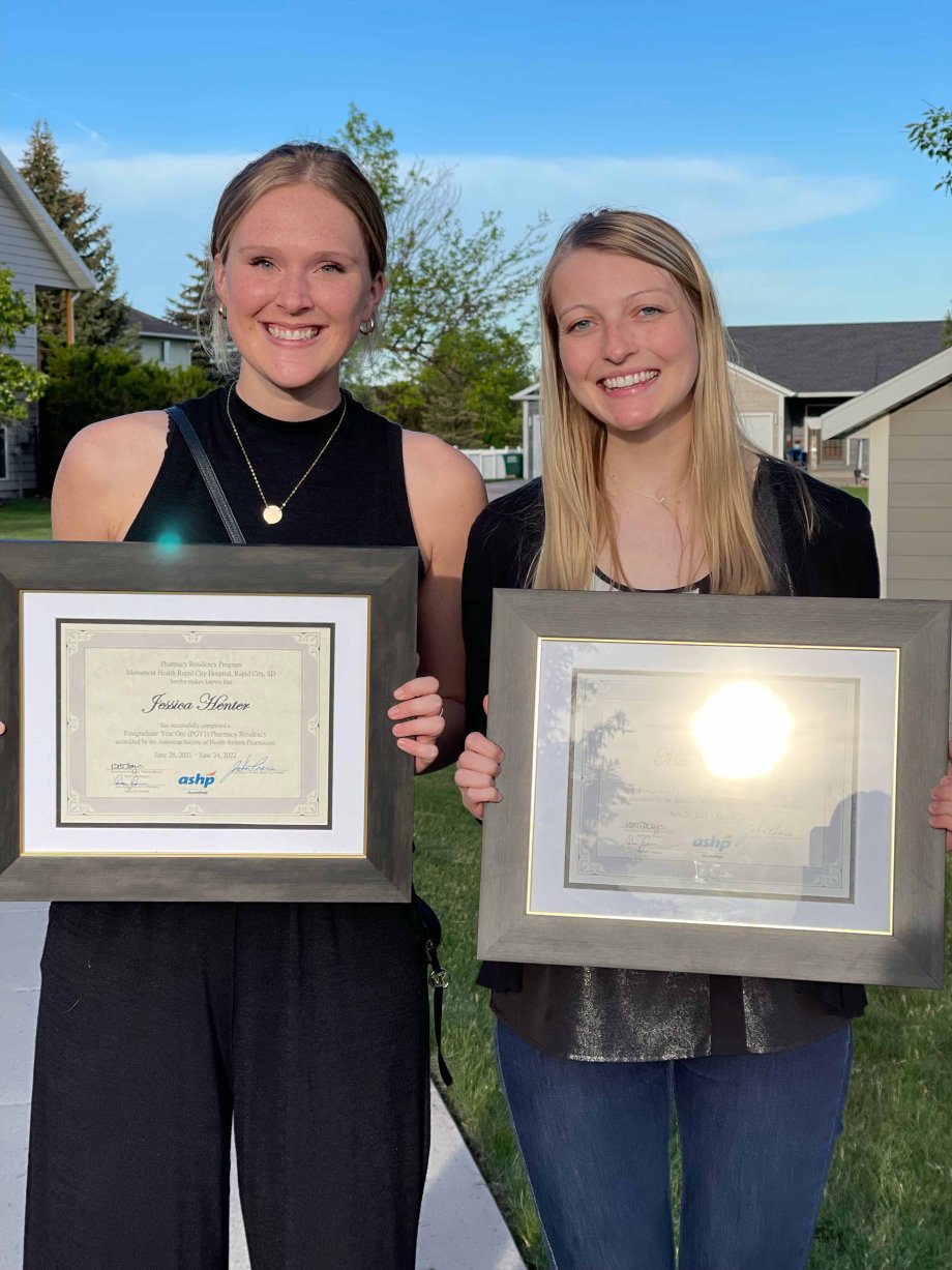 Jessica Henter, left, and Melanie Heeren hold plaques honoring them for completion of their residency at Monument Health in Rapid City.
