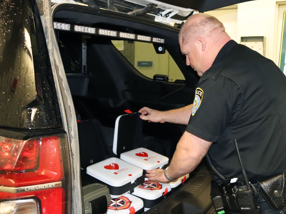 Office placing AEDs in patrol vehicle