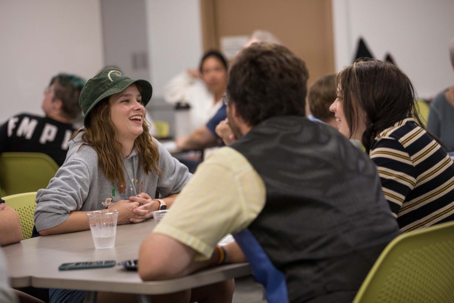 Group of three students sit at a table during a trivia night activity