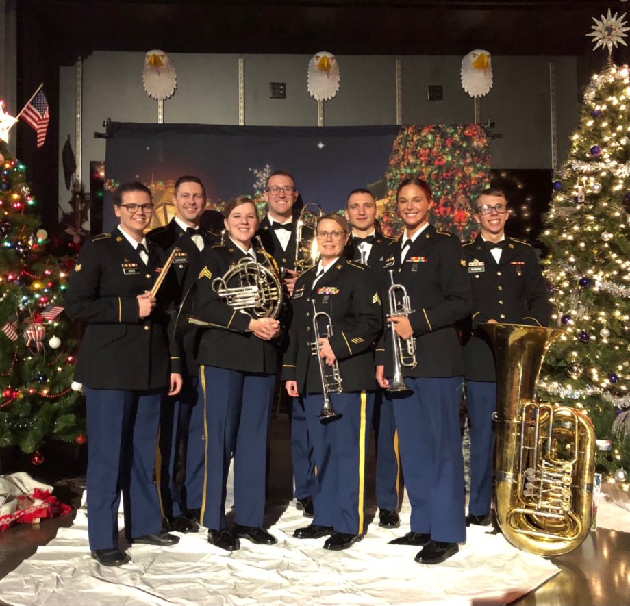 Members of the Mission Essential Brass from the 147th Army Band pose in front of a Christmas tree