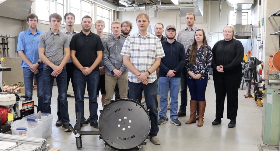 Space Trajectory team members pose by the excavator wheel that will be used in their Break the Ice Lunar Challenge project. Members are, from left, Max Selbach, Ben Louwagie, Tom Neumeister, John Ziegelski, Devin Lundberg, Parker Brandt, adviser Todd Letcher, Brock Heppner, Tate Mueller, Austin Lohsandt, Elaine Hines and Allea Klauenberg. Not pictured are Ben Diersen and adviser Jason Sternhagen.