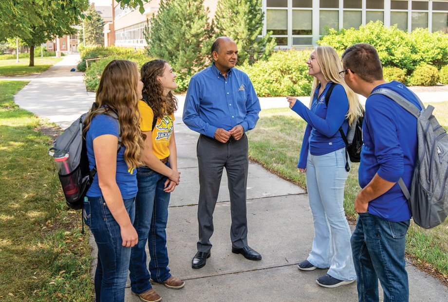 Vikram Mistry visits with students outdoors on the South Dakota State University campus.
