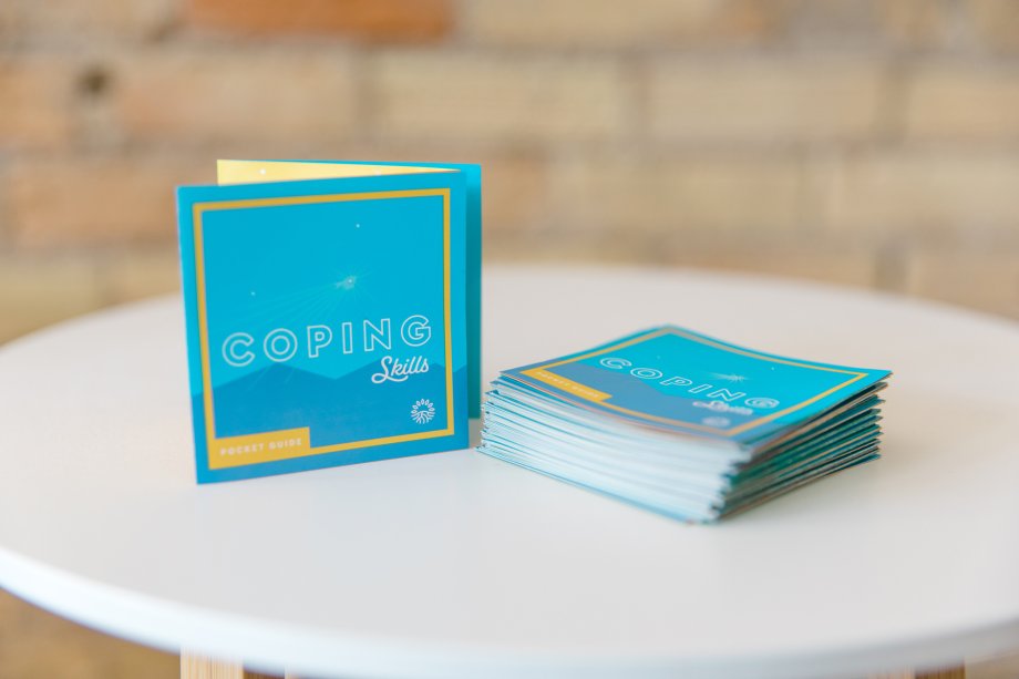 Stacks of Strengthening the Heartland's Coping Skills Pocket Guide on a table