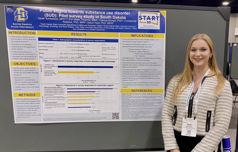Sarah Schweitzer stands next to her research poster at the American Public Health Organization 2023 Annual Meeting and Expo