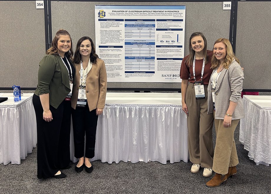 From left, Jaden Gossen, Allie Bladholm, Ellie Balken and Tara Gilk present their research poster at the 2023 Midyear Clinical Meeting of the American Society of Health-System Pharmacists.