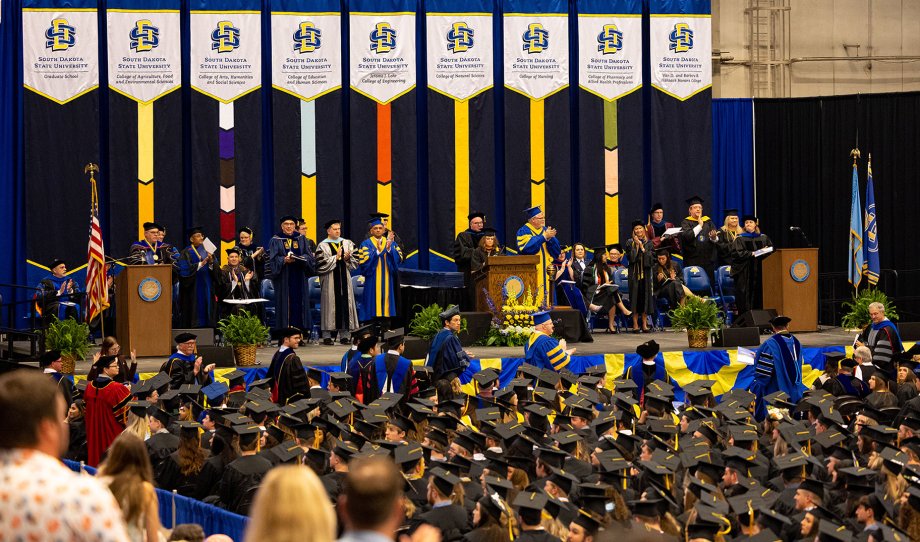 South Dakota State University graduates, officials and dignitaries are shows at a spring 2023 commencement ceremony at the Dakotah Bank Center in Brookings.