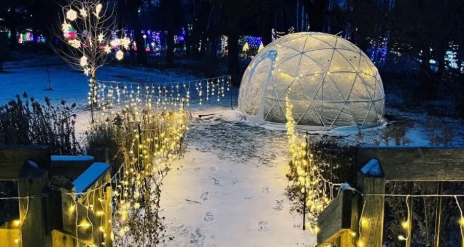 Outdoor igloo at Frostfest surrounded by snow and a ligthed path.