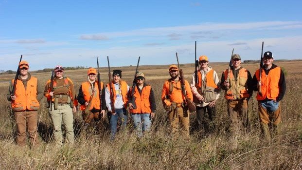 Pheasants Forever Club stands ready for hunting with their hunter orange and firearms.