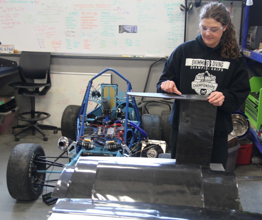 Sianne Downes, a senior mechanical engineering major and a member of the SDSU swimming team, assembles a part of the front wing for the college's Formula race car.