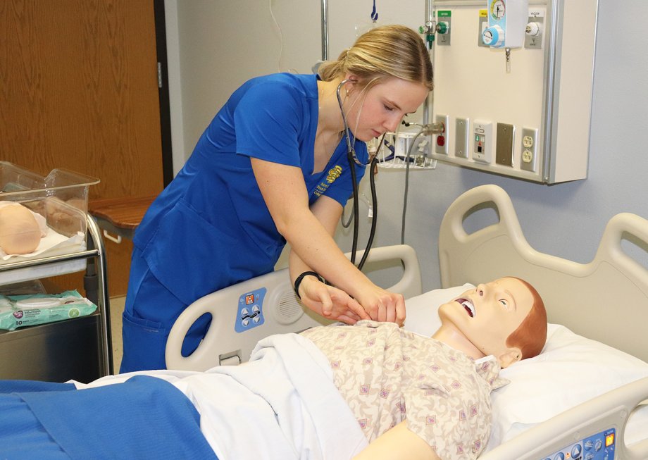 Ellise Otheim takes vital signs on a mannequin in a College of Nursing simulation lab on campus.