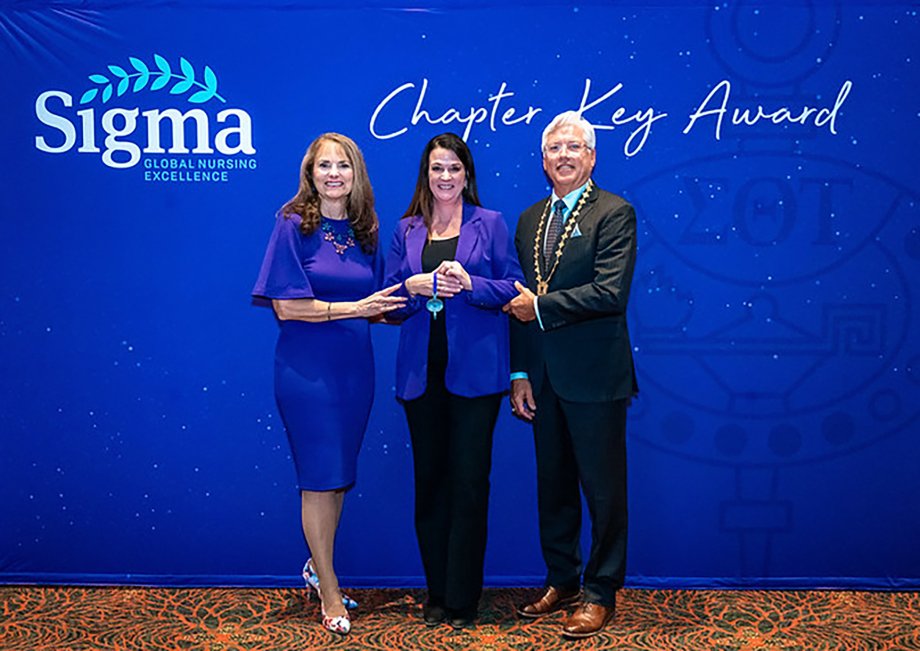 Brandi Pravecek, president of the Phi Chapter of Sigma Theta Tau at South Dakota State University and clinical assistant professor in SDSU's College of Nursing, shown at center, accepts the 2023 Chapter Key Award from Sigma Theta Tau, an international honor society of nurses.