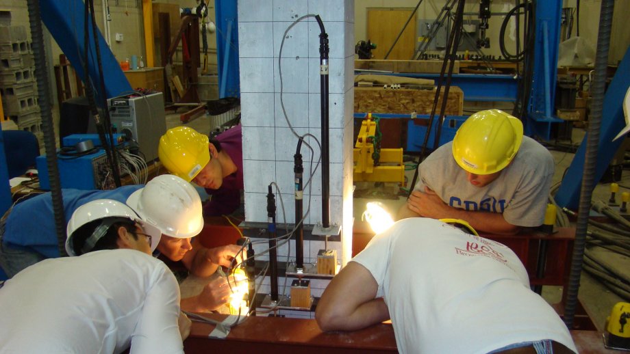 Researchers inspecting a concrete column after testing