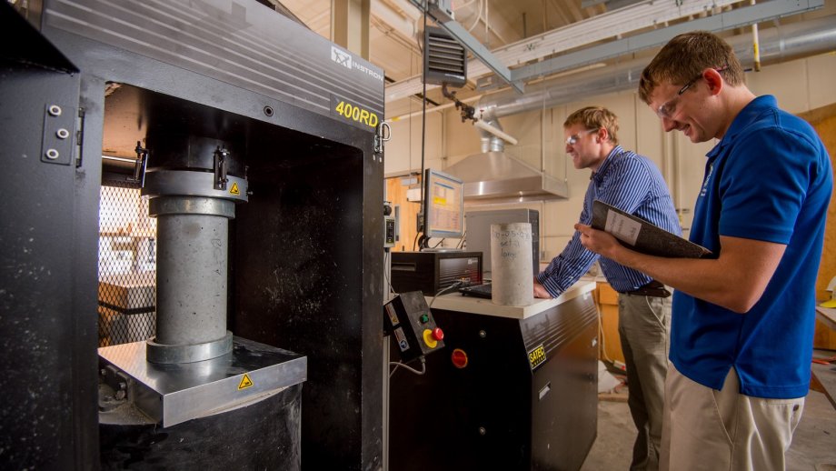 Researchers using the concrete compression testing machine