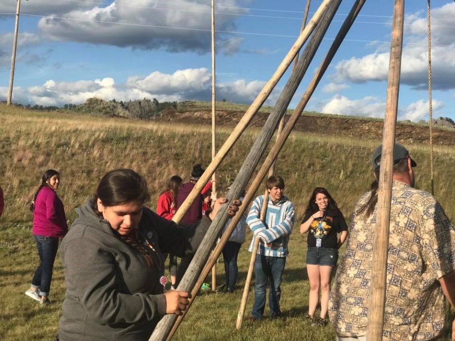 "Students work together to erect a traditional tipi"