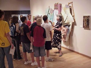 Museum volunteer discussing a piece of artwork to a group of visitors