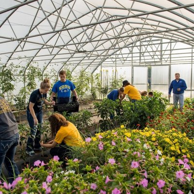 Students and instructor working in a greenhouse.