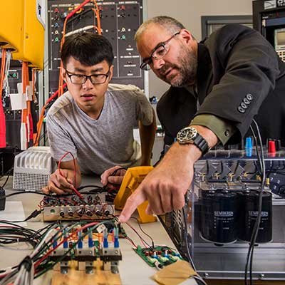 student and professor in electronics lab