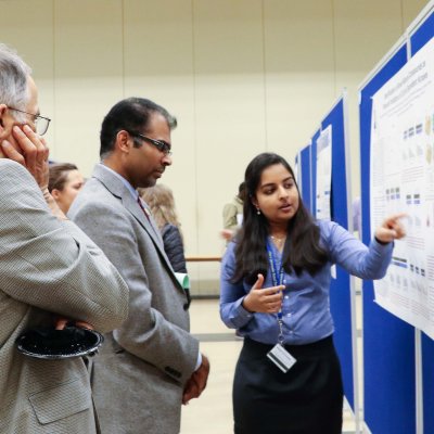 Student explaining her research to professors 