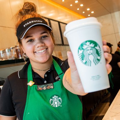 Starbucks baristra holding out a cup of coffee