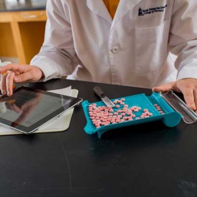 Pharmacy student counting pills with an iPad