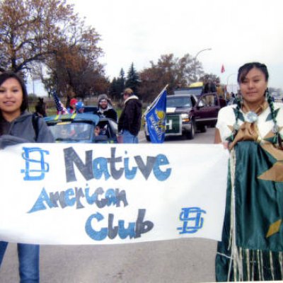 Native American Club Banner held by 2 female students during Hobo Day Parade