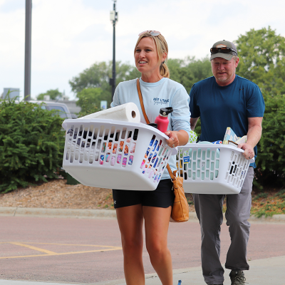 parents moving in student items with laundry baskets