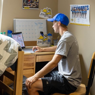A male SDSU student sitting a desk