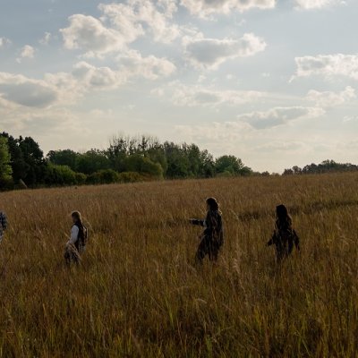 Students walking through tall grass.