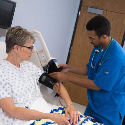 Nursing student is measuring patient's blood pressure.