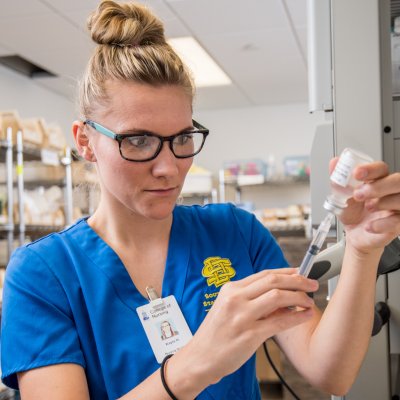 Nursing student is filling a needle with medicine