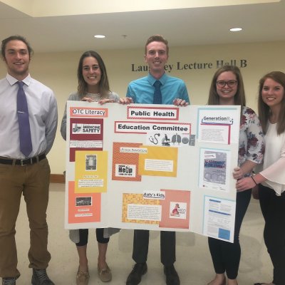 Students with a public health education poster