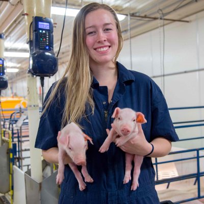 student holding piglets