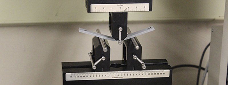 Material test equipment performing a test on a metal bar