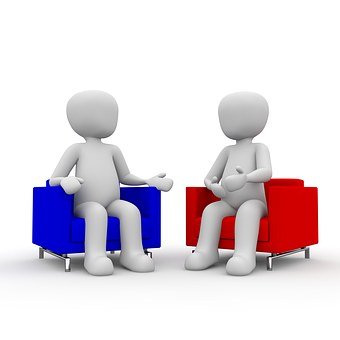 two people sitting in chairs speaking