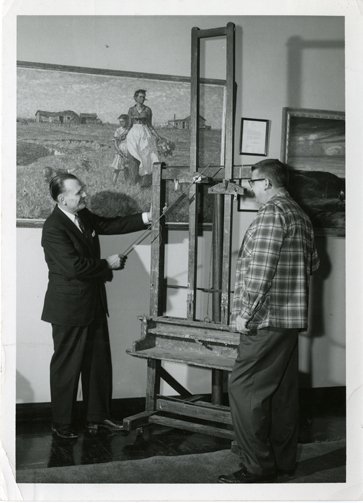 South Dakota State University President Hilton M. Briggs and Pugsley Union Manager Harlan R. Olson examine Harvey Dunn’s easel on display in the Pugsley Student Union.