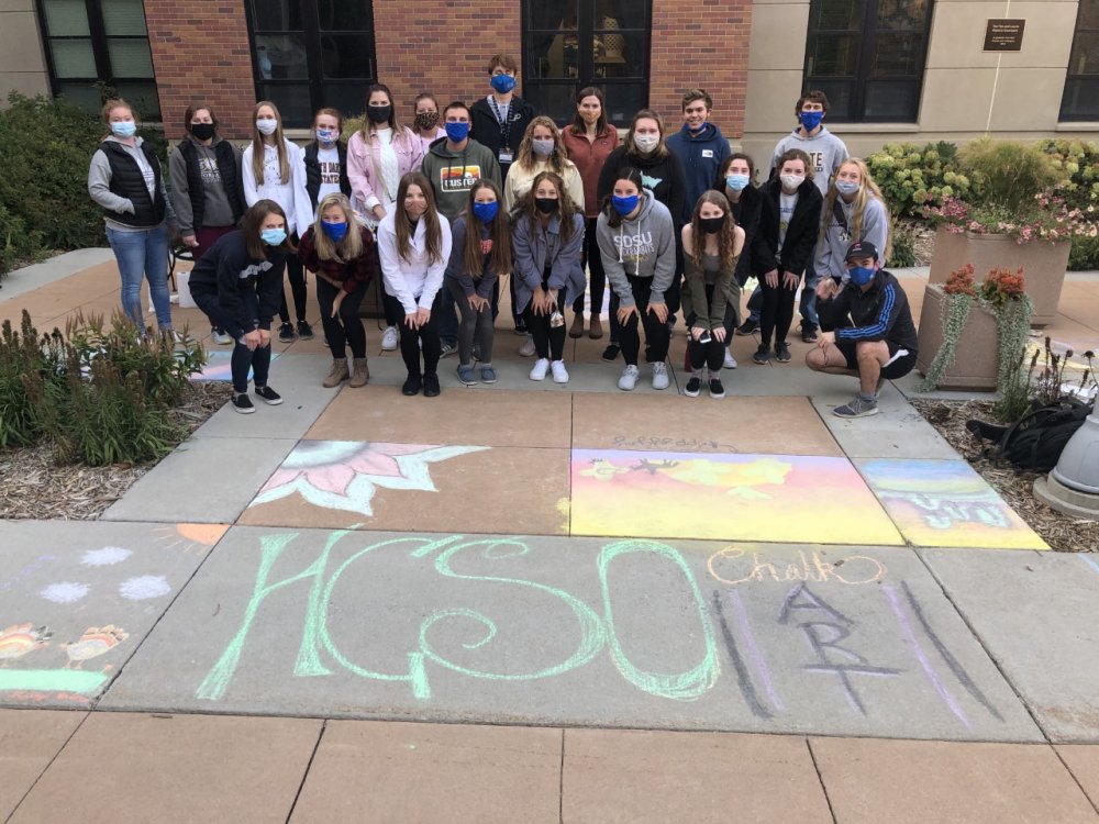 Students pose outside of Honors Hall at HCSO chalk night. 