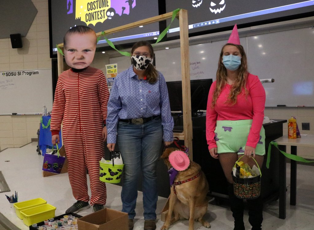Three students pose in their Halloween Costumes. 