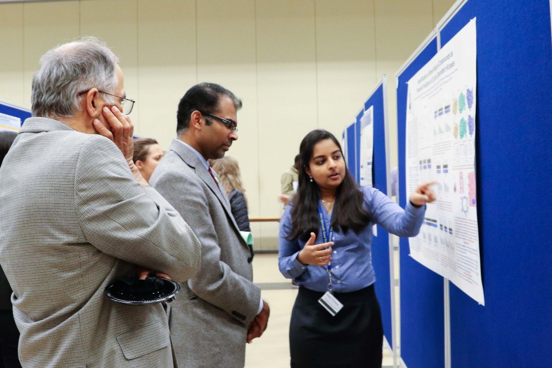 Student explaining her research to professors 