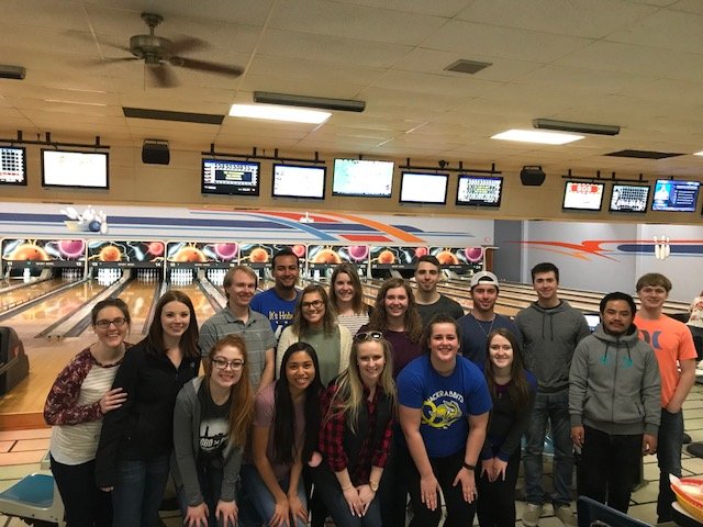 Students at the retreat pose in the bowling alley for a photo.