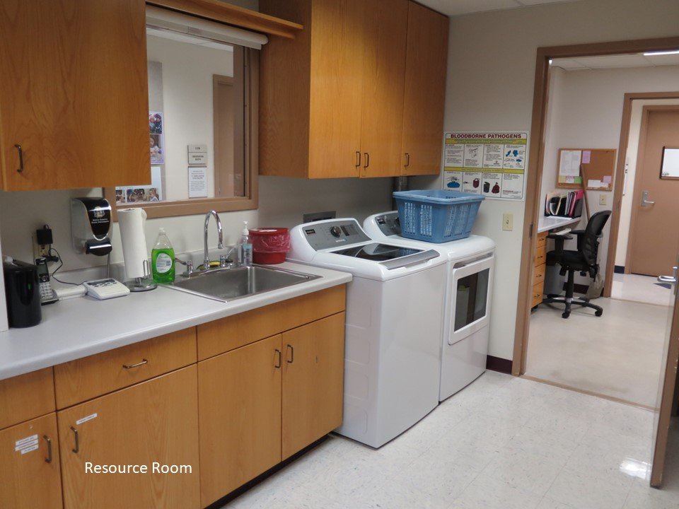 The resource room where the program washer and dryer is housed as well as a variety of materials which are stored in cabinets.
