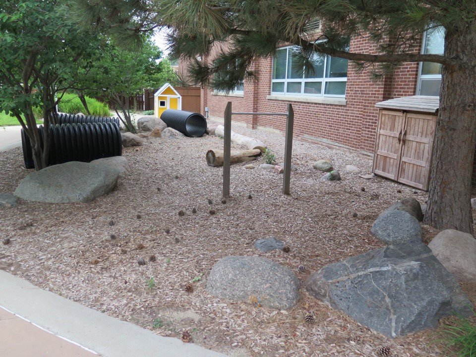 View of the tunnels and climbing rocks and logs in the playground.